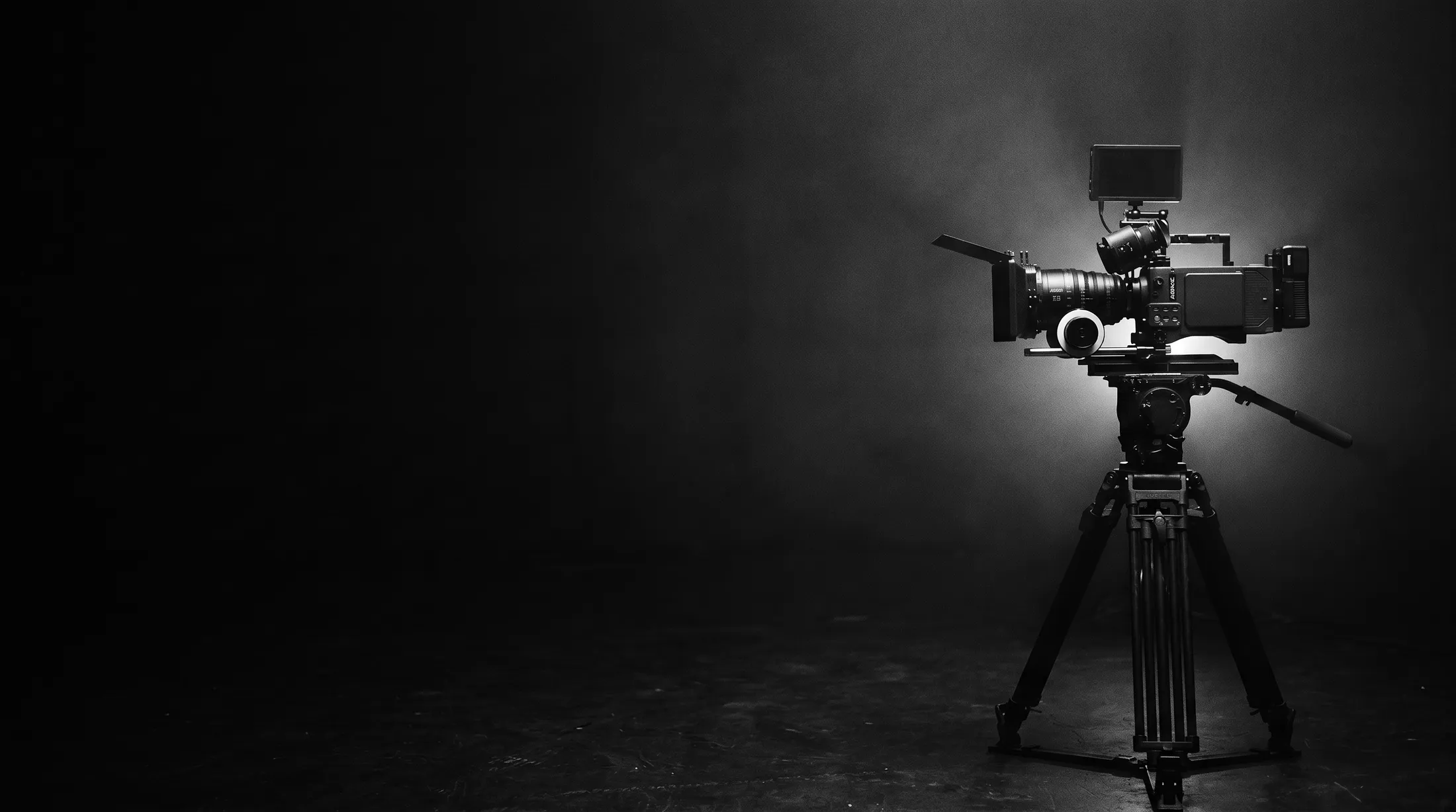 A cinema camera on a tripod on a dark music video set
